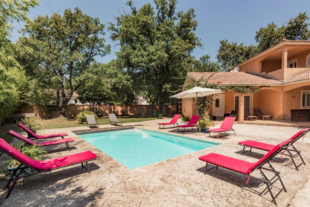 a swimming pool with lounge chairs and a house at Residence de tourisme Le clos des Vendanges in Moriani Plage