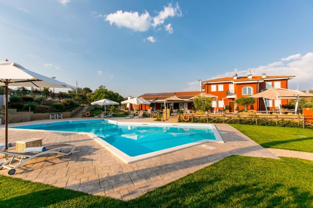 a swimming pool in a yard with a house in the background at Il Podere di Marfisa in Farnese