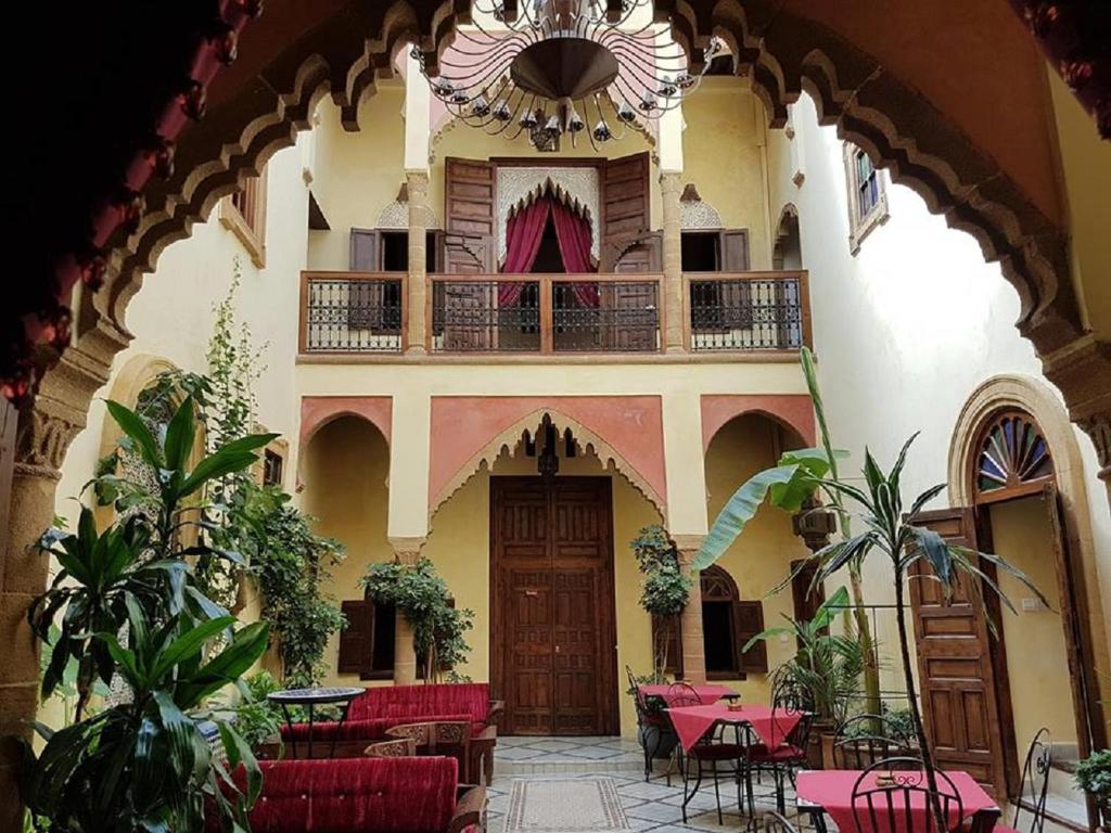 a courtyard with tables and chairs in a building at Riad Marlinea in Sale