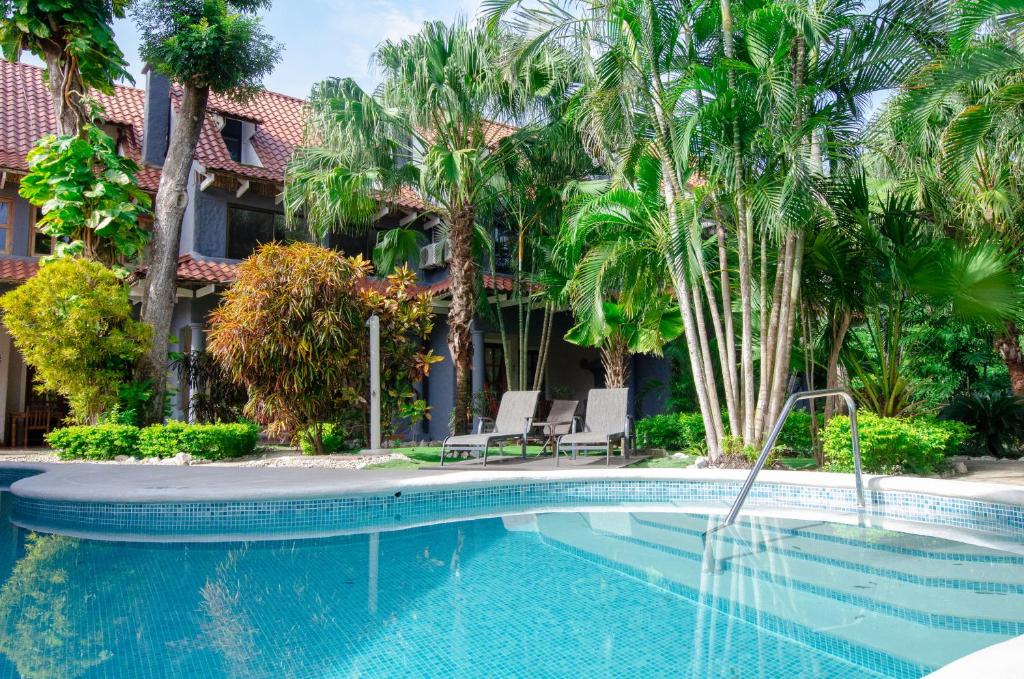 uma piscina em frente a um edifício com palmeiras em Hotel El Manglar em Playa Grande