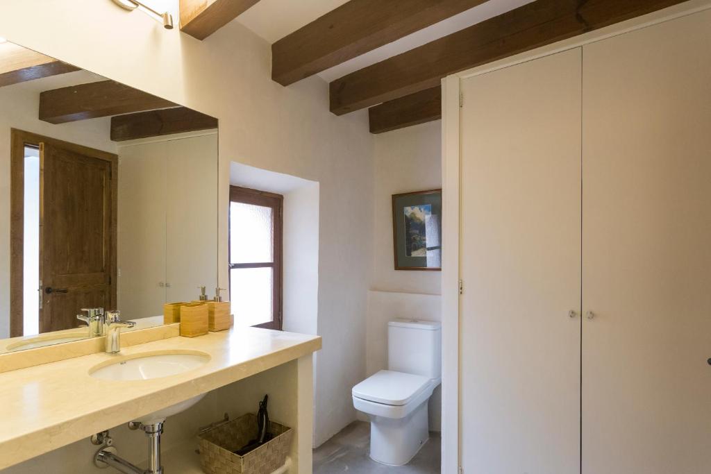 uma casa de banho com um lavatório e um WC em Font Fresca House em Deia