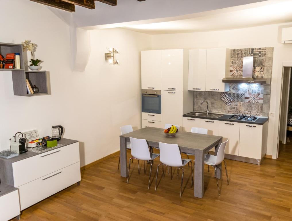 a kitchen with white cabinets and a table and chairs at La Campanella in Modena