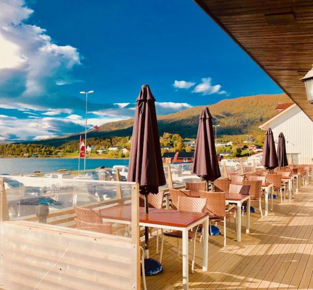 una terraza con sillas y sombrillas en un barco en Bjerkvik Hotell, en Bjerkvik
