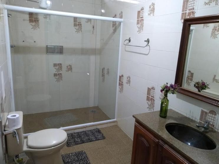 a bathroom with a shower and a toilet and a sink at Casa na orla da Praia do Forte in Cabo Frio