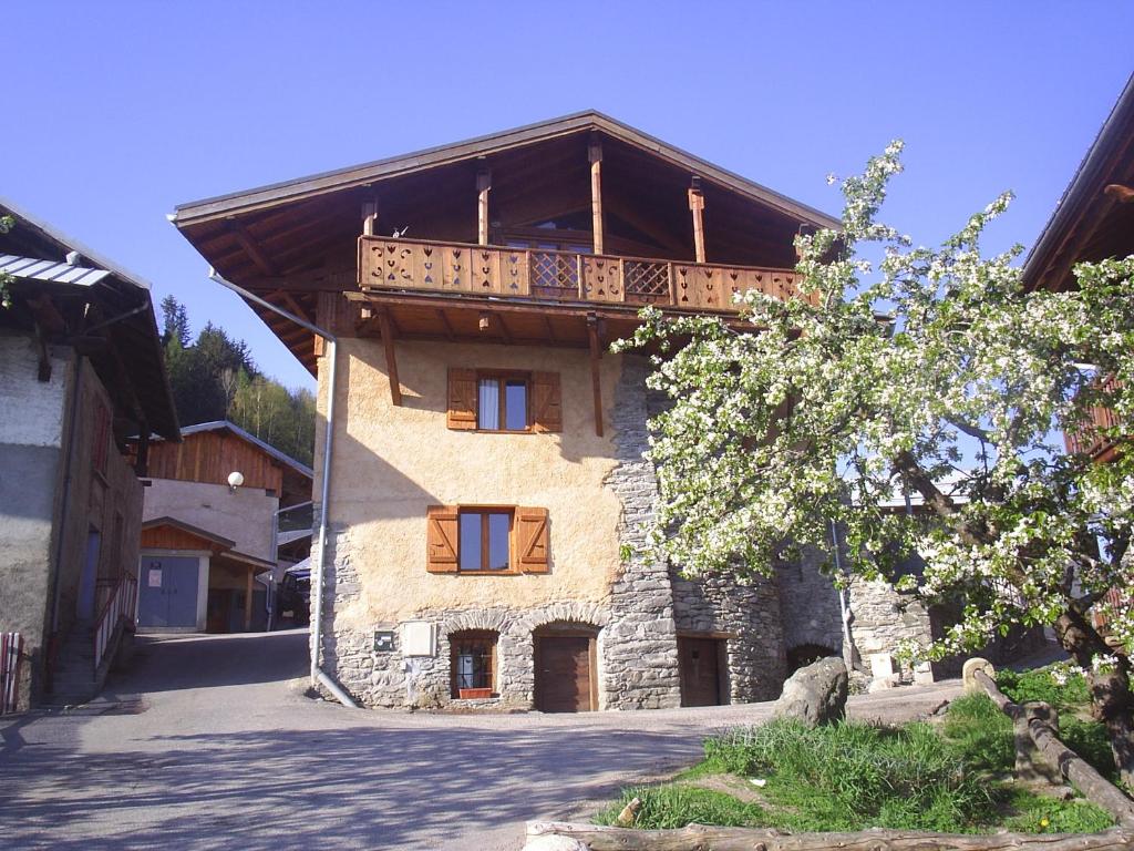 un bâtiment avec un balcon au-dessus dans l'établissement La Portette Chambres d'Hôtes, à Bellentre