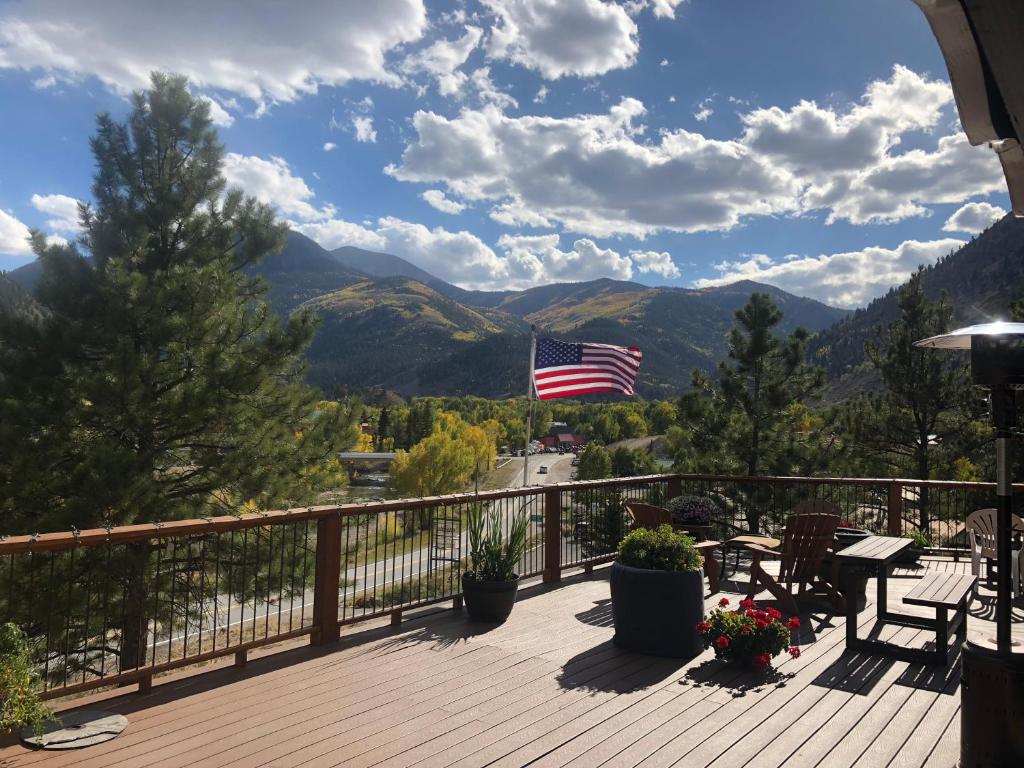 a deck with a view of mountains and an american flag at The North Face Lodge in Lake City