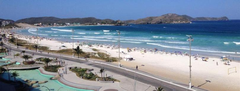 una playa con un montón de gente y el océano en Casa na Praia do Forte en Cabo Frío