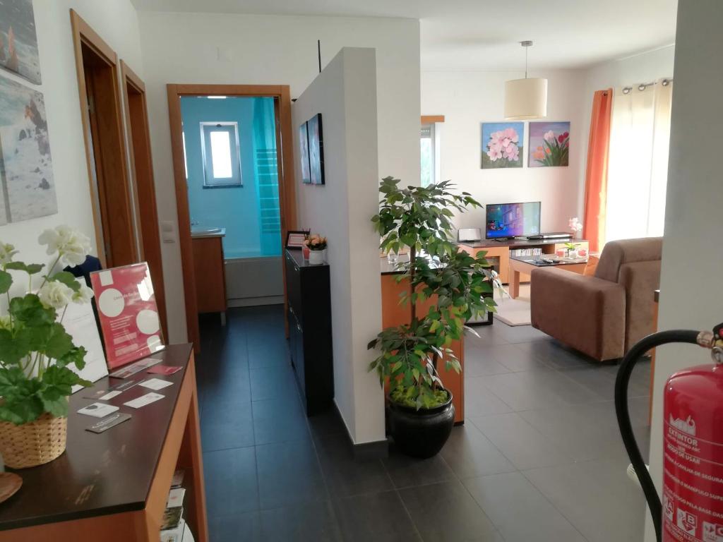 a living room with two potted plants on the floor at Apartamento BaySide - São Martinho do Porto in São Martinho do Porto