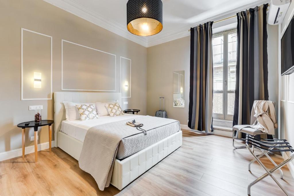 een slaapkamer met een wit bed en een groot raam bij Repubblica Exclusive Apartment in Rome