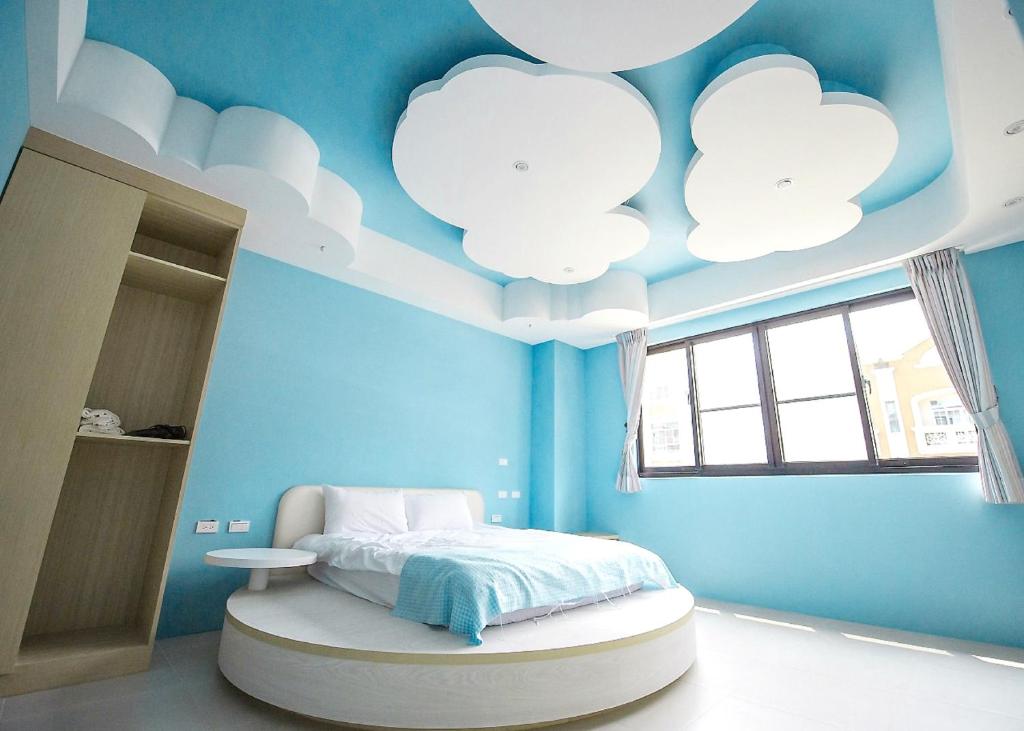 a blue bedroom with white clouds painted on the ceiling at Yellow Kite Hostel in Tainan