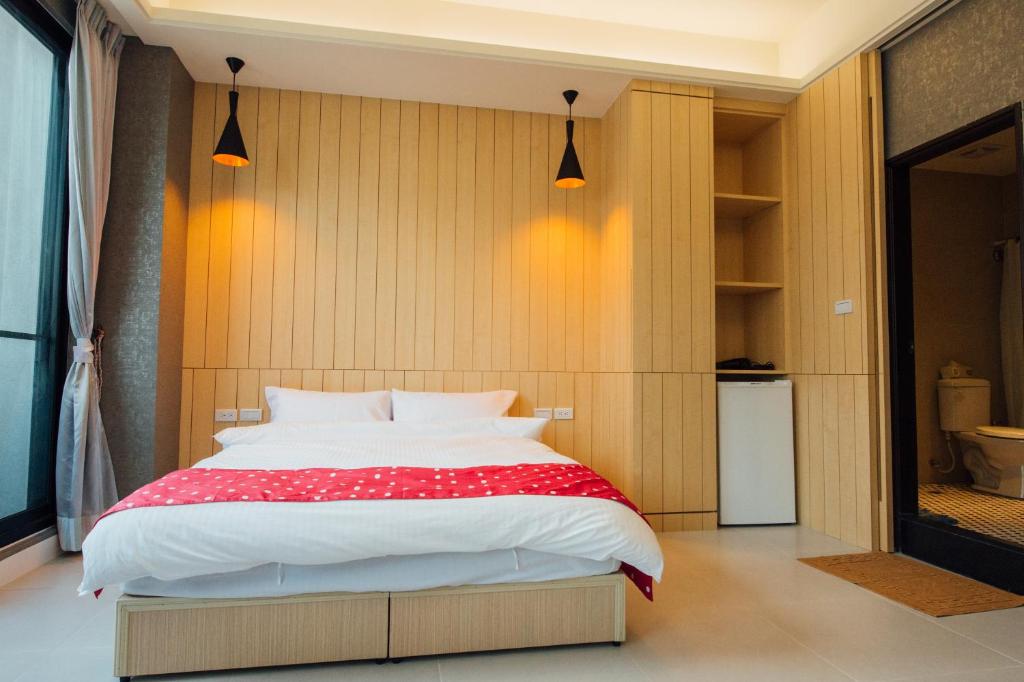 a bedroom with a bed with a red and white blanket at Yellow Kite Hostel in Tainan