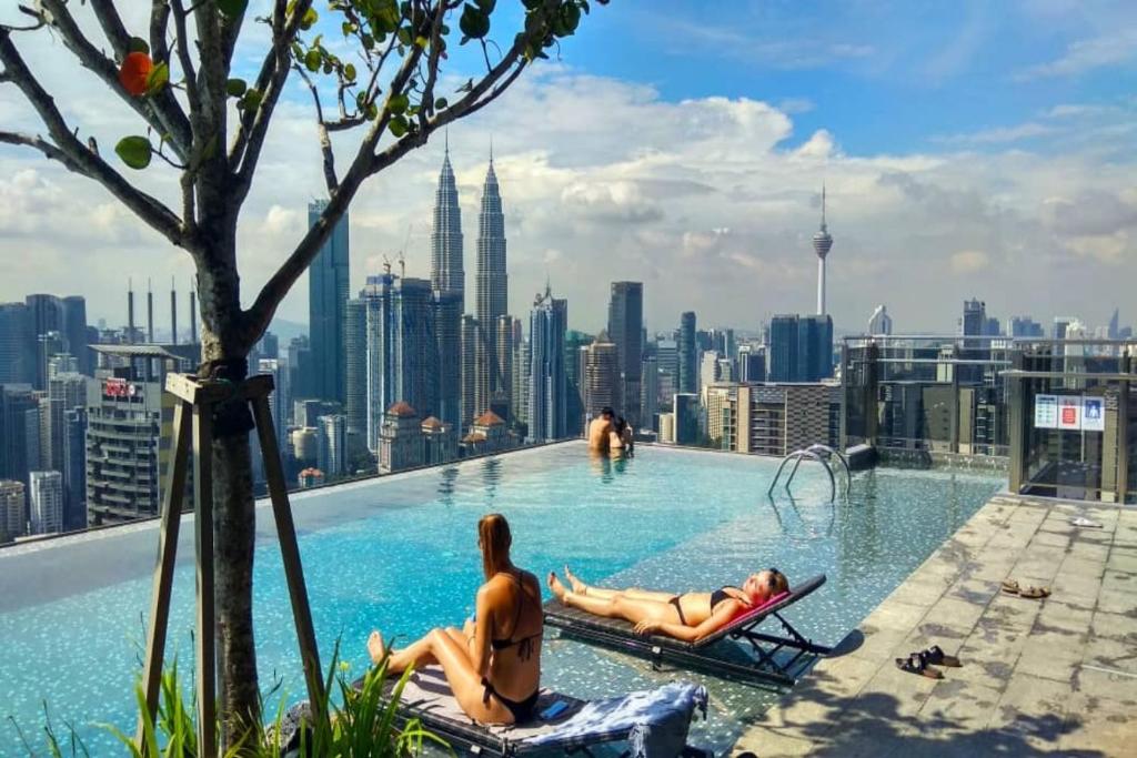 a pool on the roof of a building with a city skyline at Expressionz Suites By iHost Global in Kuala Lumpur