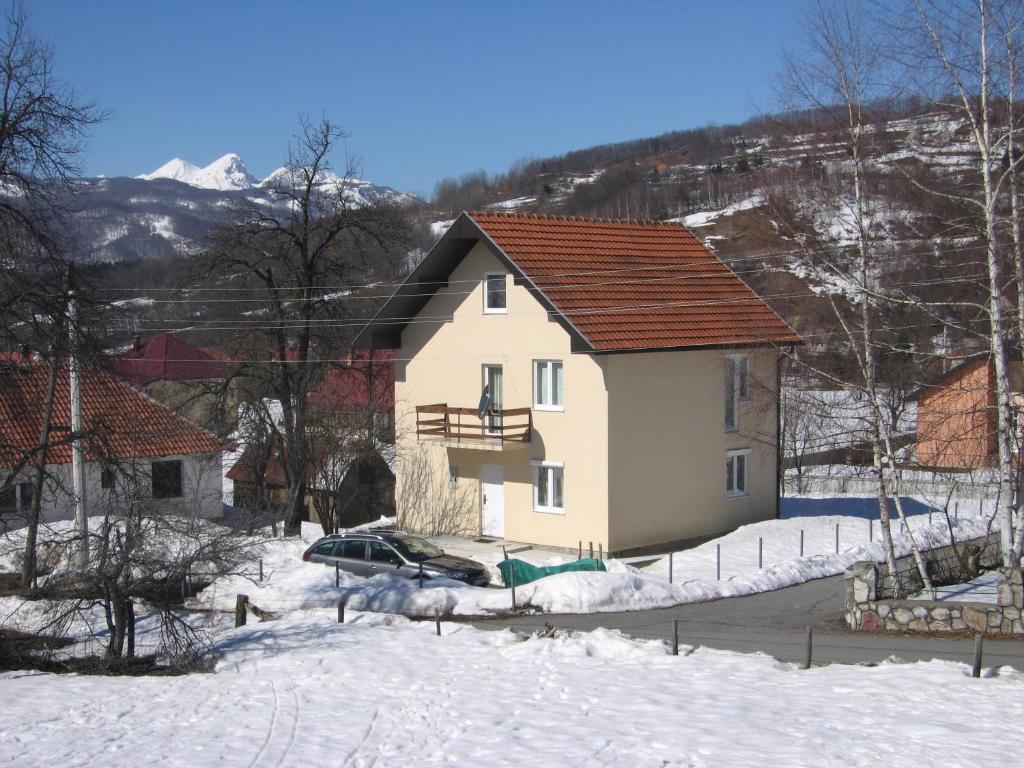 uma casa com um carro estacionado na neve em Guest House Sergey em Kolašin