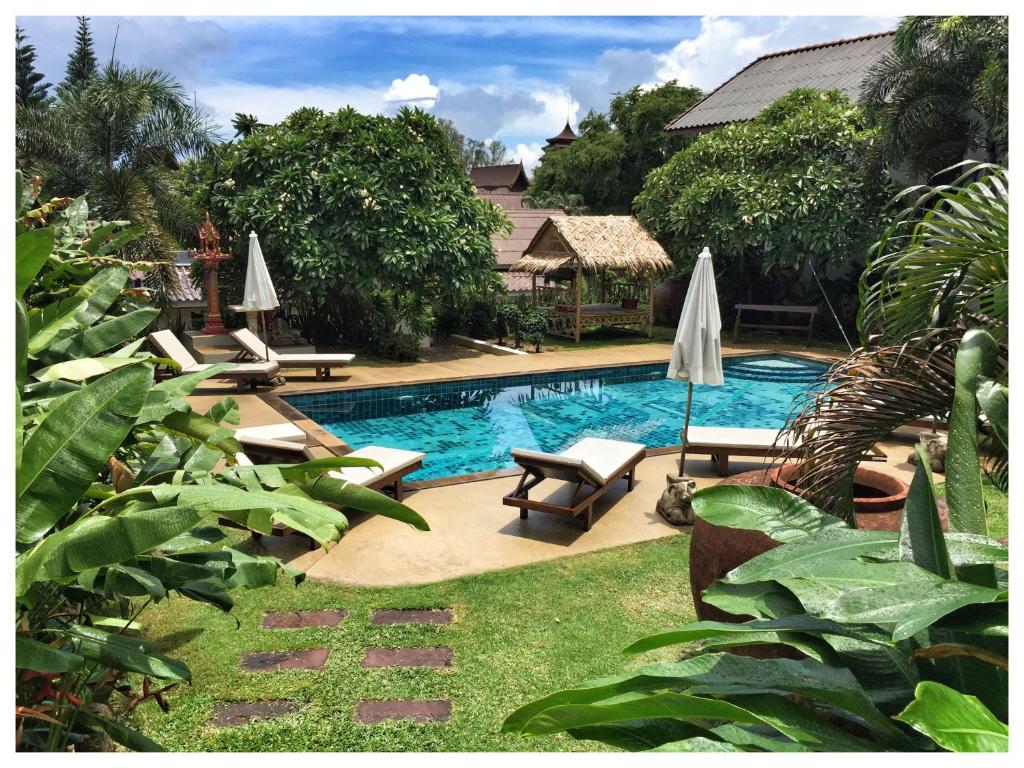 einen Pool mit Stühlen und Sonnenschirmen im Hof in der Unterkunft Visit Natural Detox Resort in Lamai