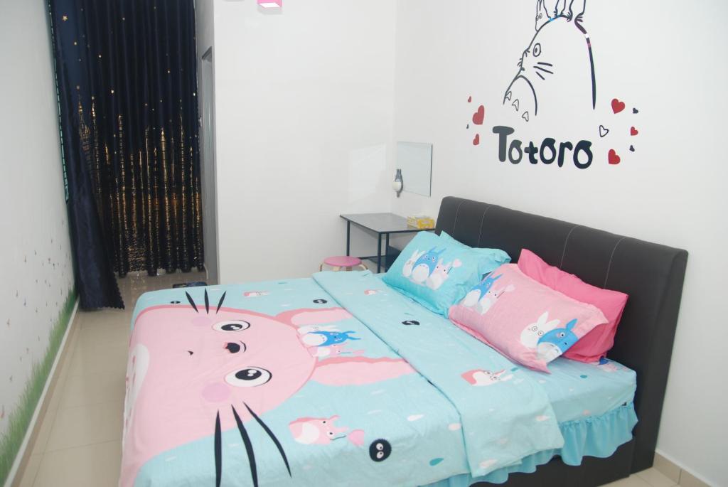 een slaapkamer met een bed en een kattendeken bij Qstay Sitiawan Townhouse (Totoro Dreams) - 梦见龙猫 in Sitiawan