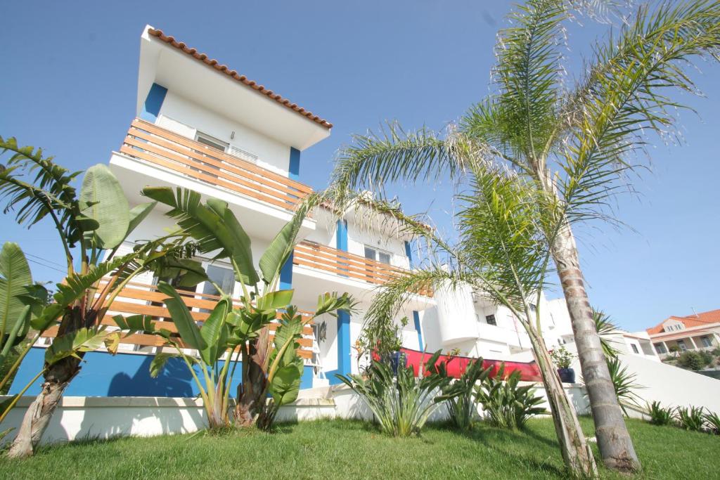 a house with palm trees in front of it at Casa Lagoa in Foz do Arelho