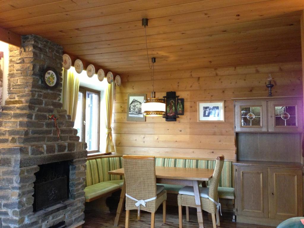 a dining room with a fireplace in a log cabin at Ciasa Cianins in San Vigilio Di Marebbe