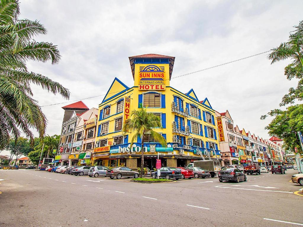 un grand bâtiment jaune avec un panneau en haut dans l'établissement Sun Inns Hotel Sunway Mentari, à Petaling Jaya