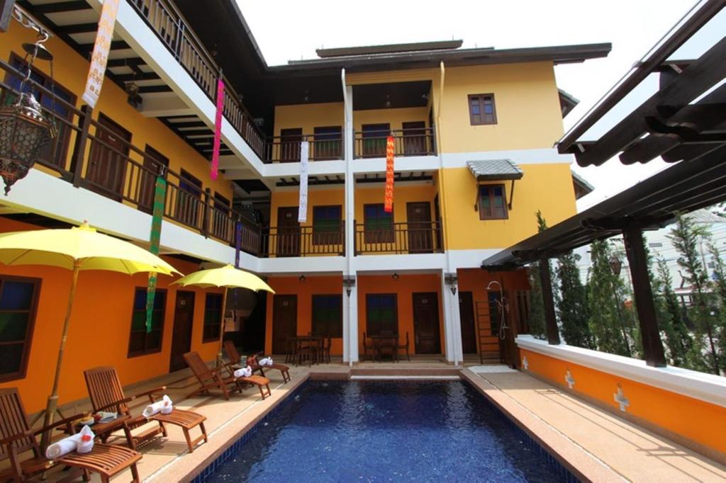 a hotel with a swimming pool in front of a building at Chiang Mai Boutique House in Chiang Mai