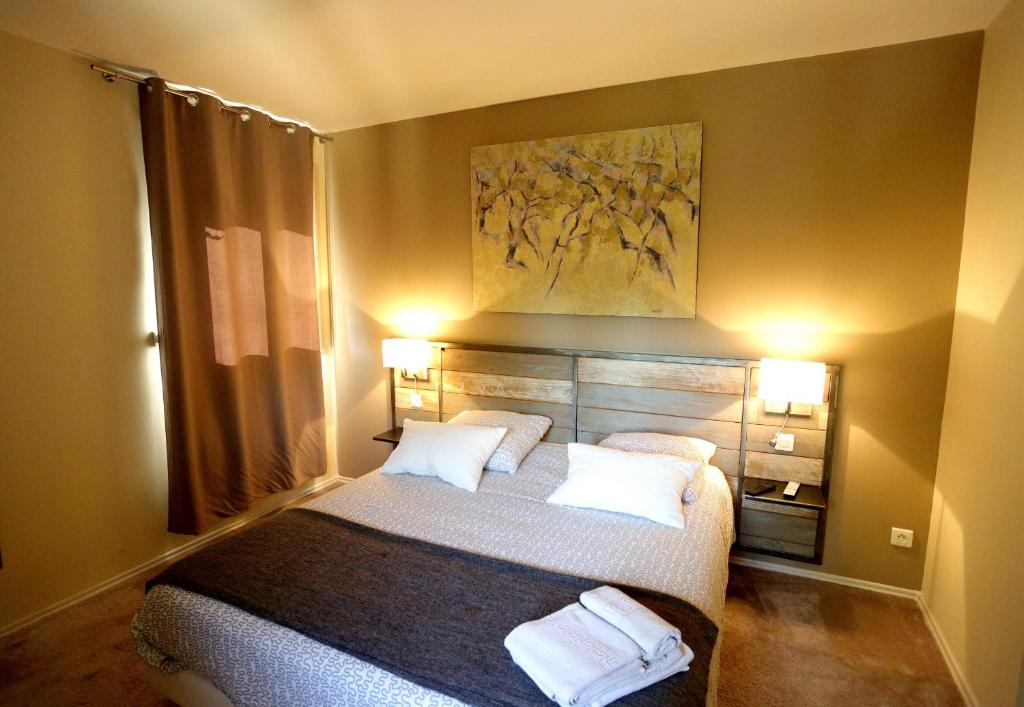 een slaapkamer met een bed met 2 witte kussens bij L'Oustaou in Château-Arnoux-Saint-Auban
