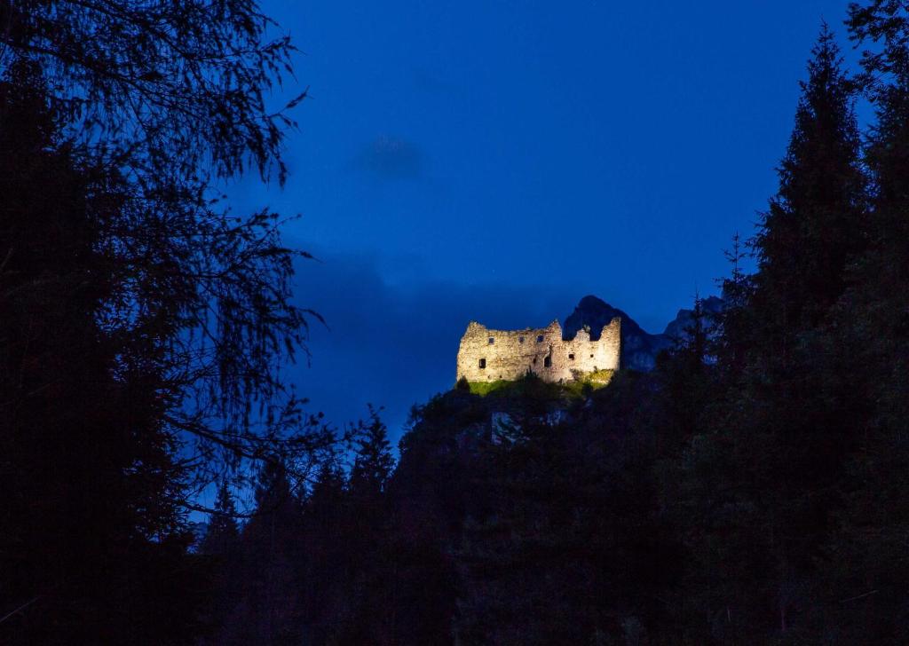 a castle sitting on top of a hill at night at Camping Castelpietra in Fiera di Primiero
