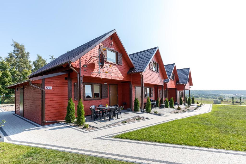 a row of wooden houses with a table in front at Domki Letniskowe Błękit in Jastrzębia Góra