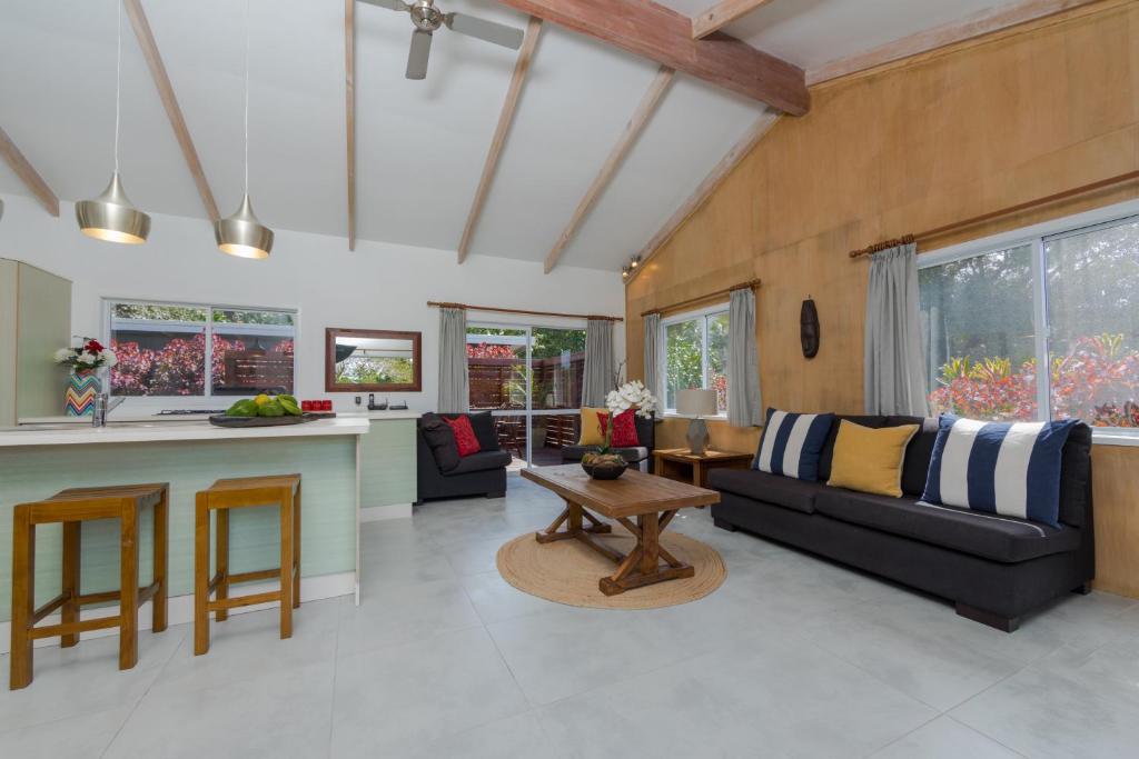 a kitchen and living room with a couch and a table at Maine Villa in Rarotonga