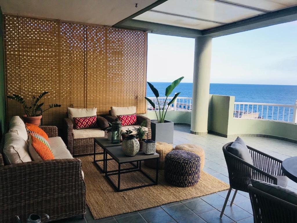 una sala de estar con sofá y sillas y el océano en La Casa Verde, en Radazul