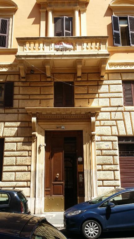 una macchina blu parcheggiata di fronte a un edificio di Hotel Ercoli House a Roma