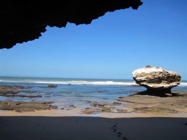 ein Strand mit einem großen Felsen im Wasser in der Unterkunft Koensrust Sea Farm in Vermaaklikheid