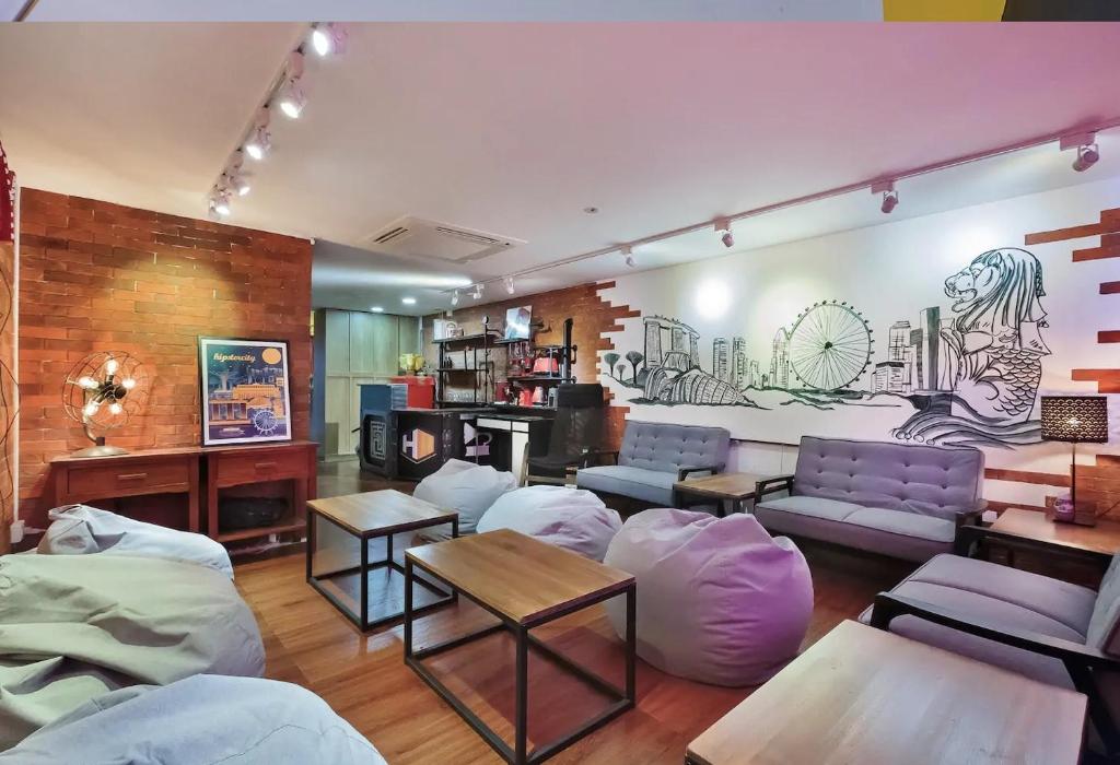 una sala de estar con muebles de color púrpura y un mural en hipstercity hostel, en Singapur