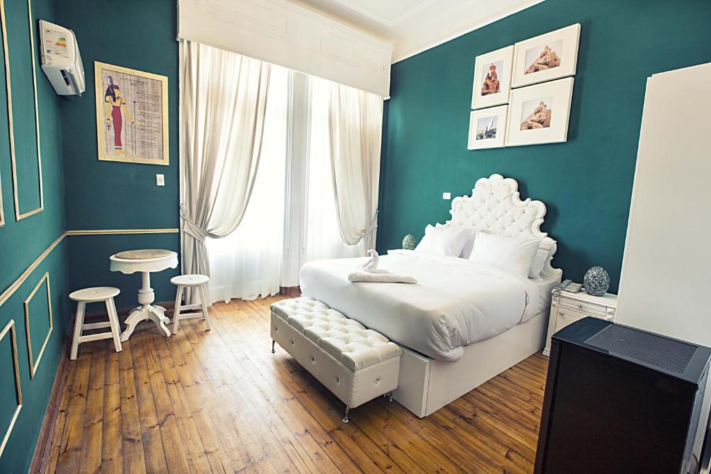um quarto com uma cama branca e uma parede azul em Tahrir Plaza Suites - Museum View em Cairo