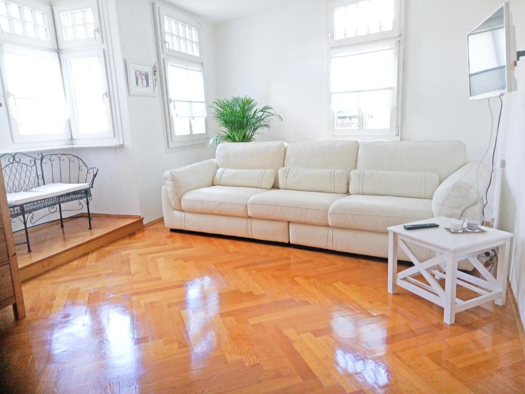 a living room with a white couch and a table at VIKARO Apartment in Monschau