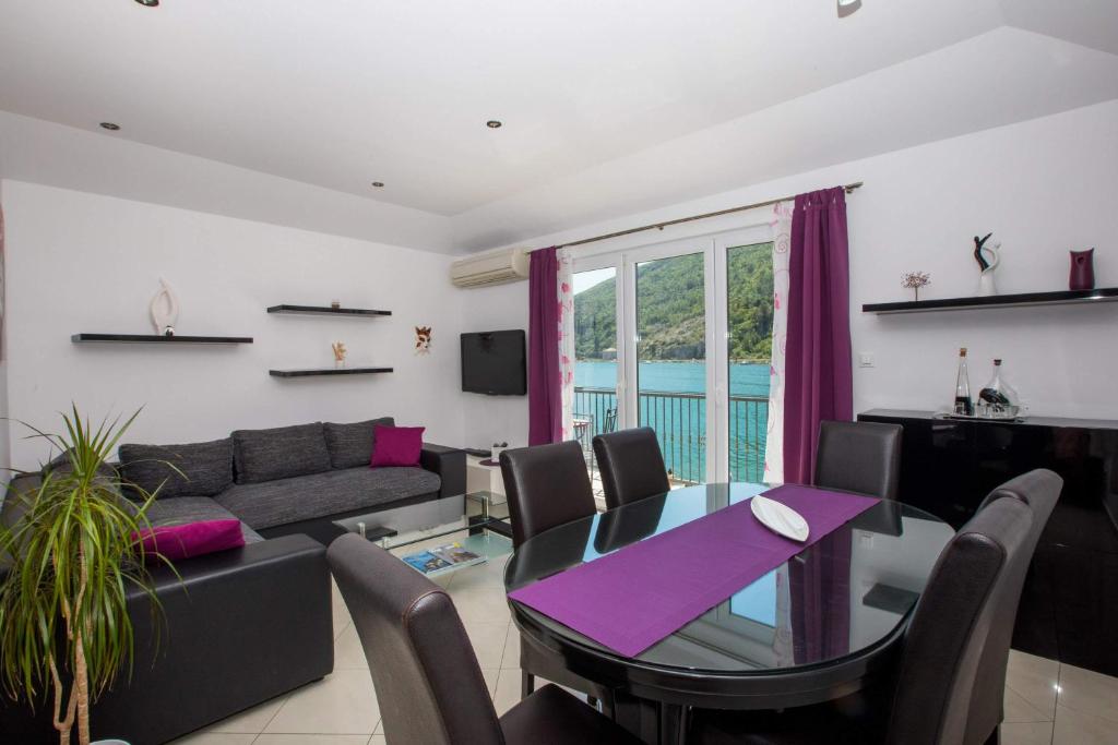 a living room with a table and a couch at Apartment River Rose in Mokošica