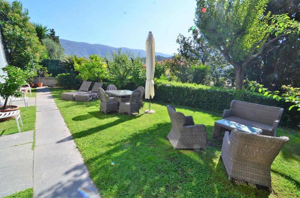 a yard with chairs and a table and an umbrella at Villa Margherita in Levanto