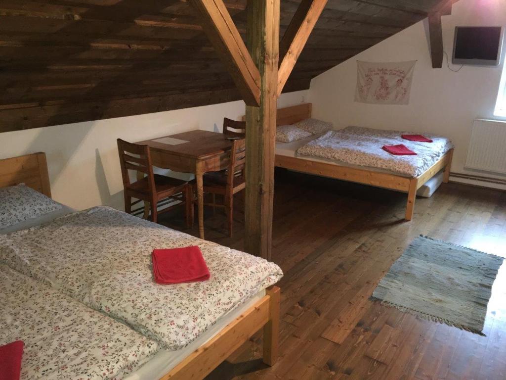 una camera con due letti e un tavolo e un tavolo con sedie di Penzion Olesnice a Zlatá Olešnice