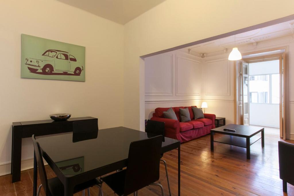 a living room with a red couch and a table at Lisbon City Center Apartment in Lisbon
