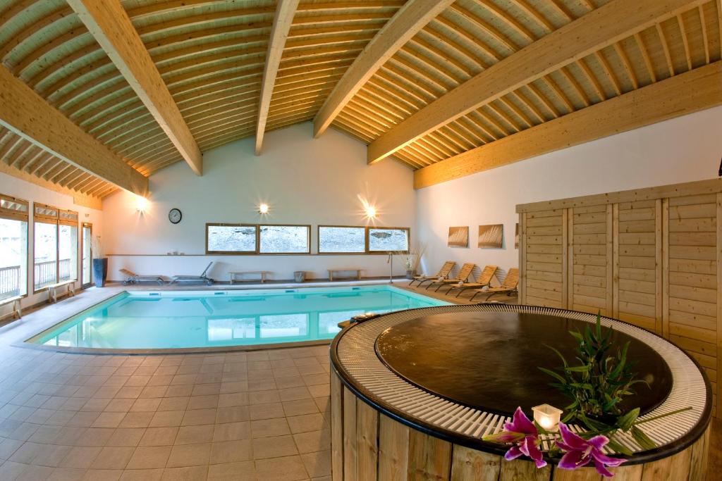 オレルにあるMontagne Duplex-Orelle 9 pers. avec SPAの木製の天井の大きな屋内プール