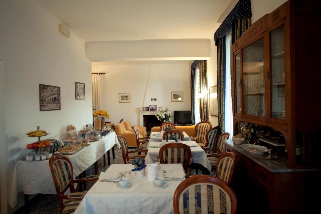 a dining room with tables and chairs with white tablecloths at Villa Margherita in Levanto