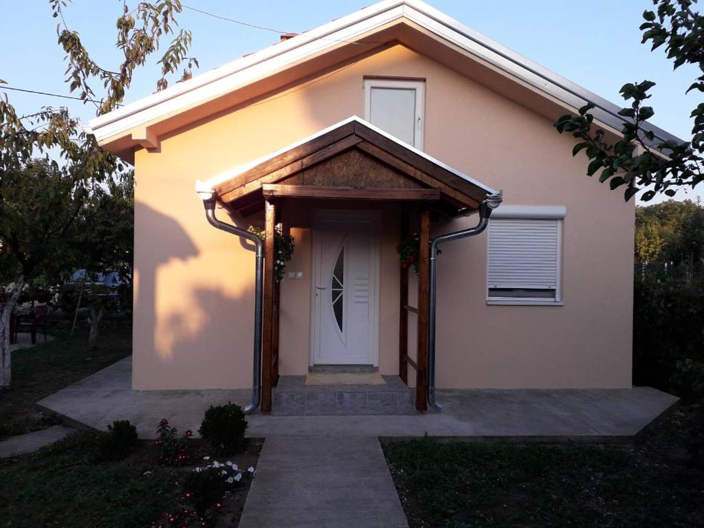 uma pequena casa com uma porta branca e um alpendre em Airplane Apartment T&T em Surčin