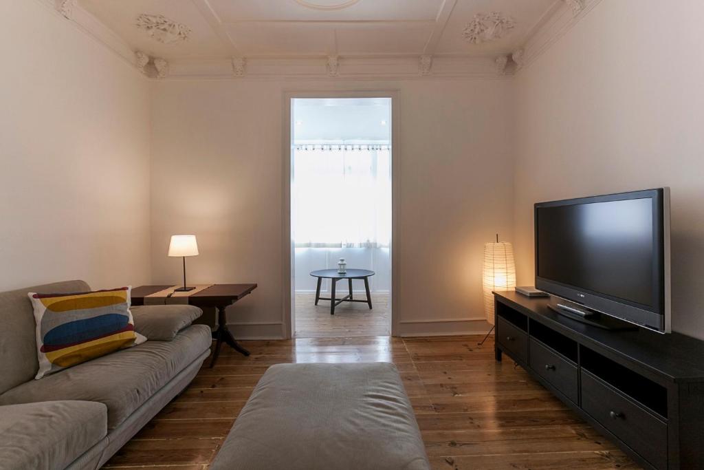 a living room with a couch and a flat screen tv at Apartment in Center of Lisbon in Lisbon