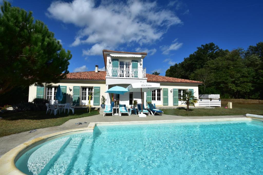 a house with a swimming pool in front of a house at Villa Florida in Le Bugue