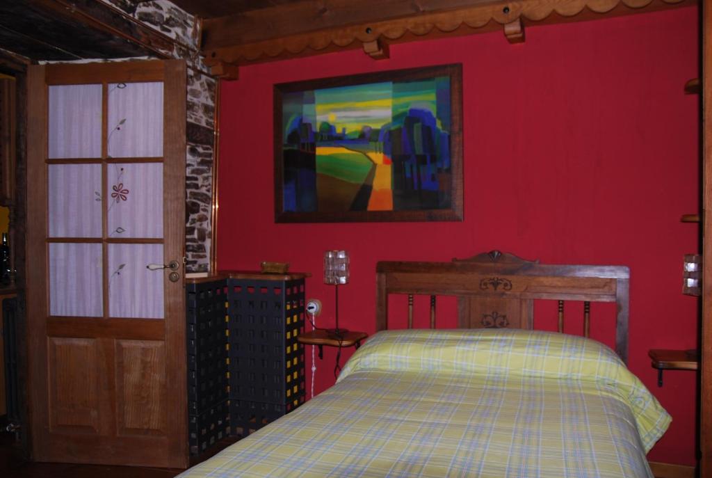 a bedroom with a bed and a red wall at Pereje Garden in Pereje
