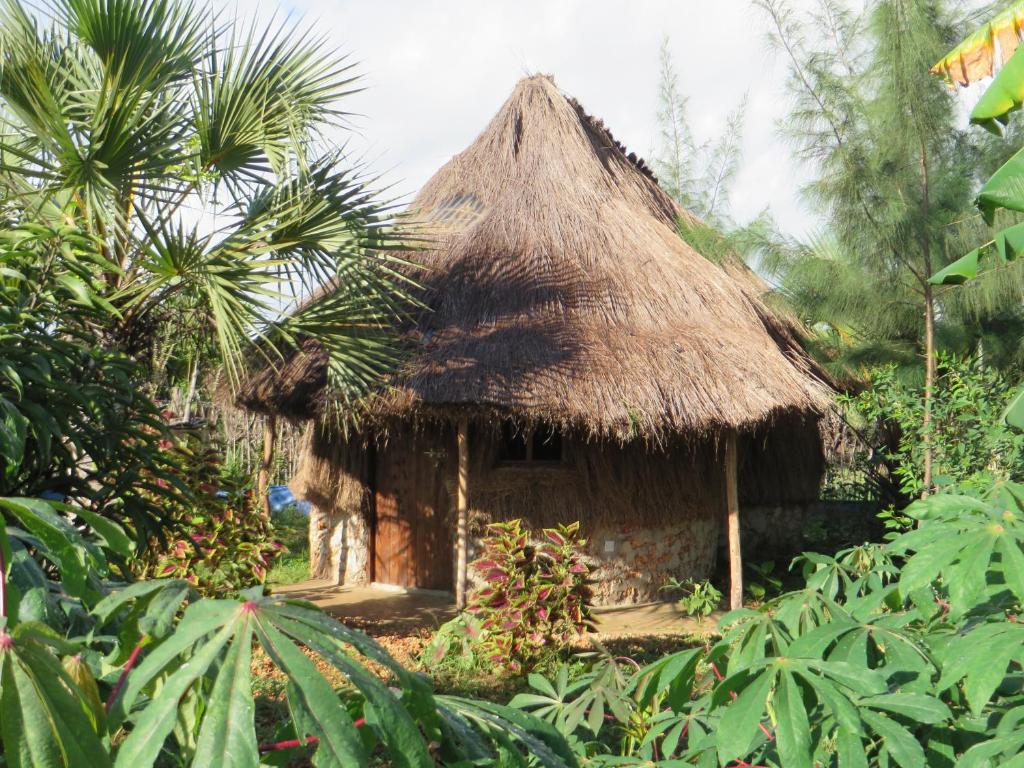 eine kleine Hütte mit einem Strohdach im Dschungel in der Unterkunft Bahati Diani House Glamping in Diani Beach