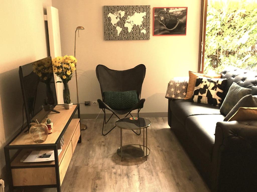 uma sala de estar com um sofá e uma cadeira em The One Suite Annecy em Annecy