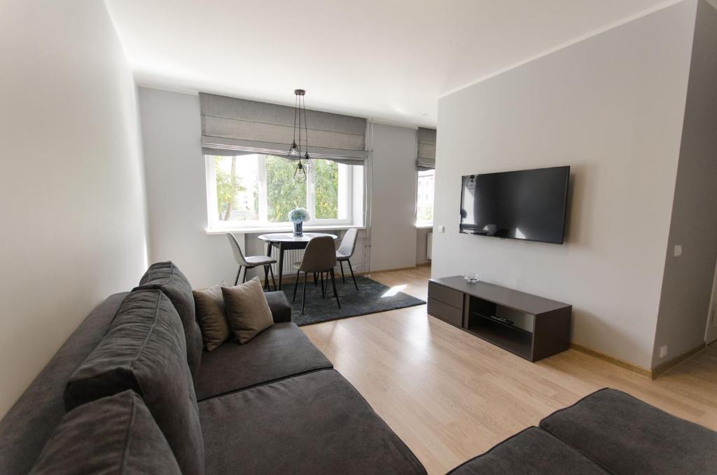 - un salon avec un canapé, une télévision et une table dans l'établissement Flat For Rent Panevezys, à Panevėžys