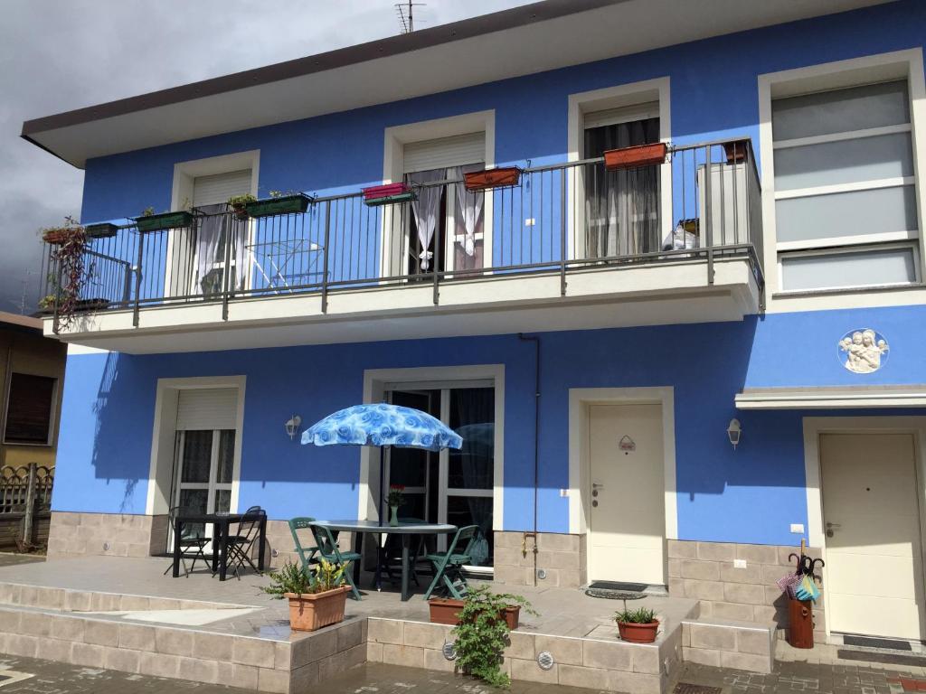 ein blaues Gebäude mit einem Tisch auf dem Balkon in der Unterkunft B&B Honey Rooms in Saronno