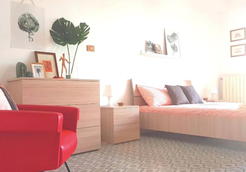 1 dormitorio con 1 cama y 1 silla roja en Confortevole appartamento nel cuore di Termoli, en Termoli