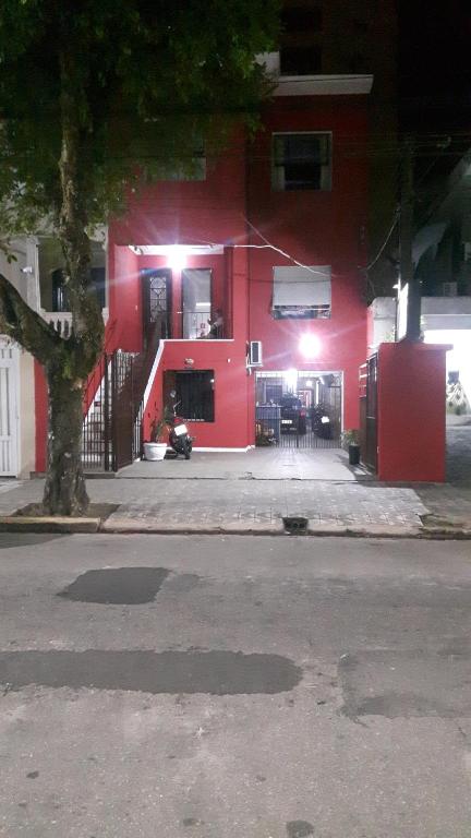 um edifício vermelho com luzes na lateral em Pousada J.C. Cazeri em Santos