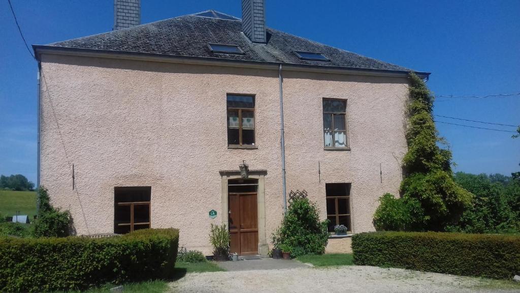 una gran casa de ladrillo con puerta marrón en Thirifays, résidence de vacances, en Chiny